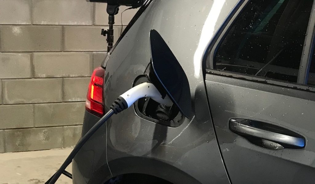 Elbil som lader med stikkontakt