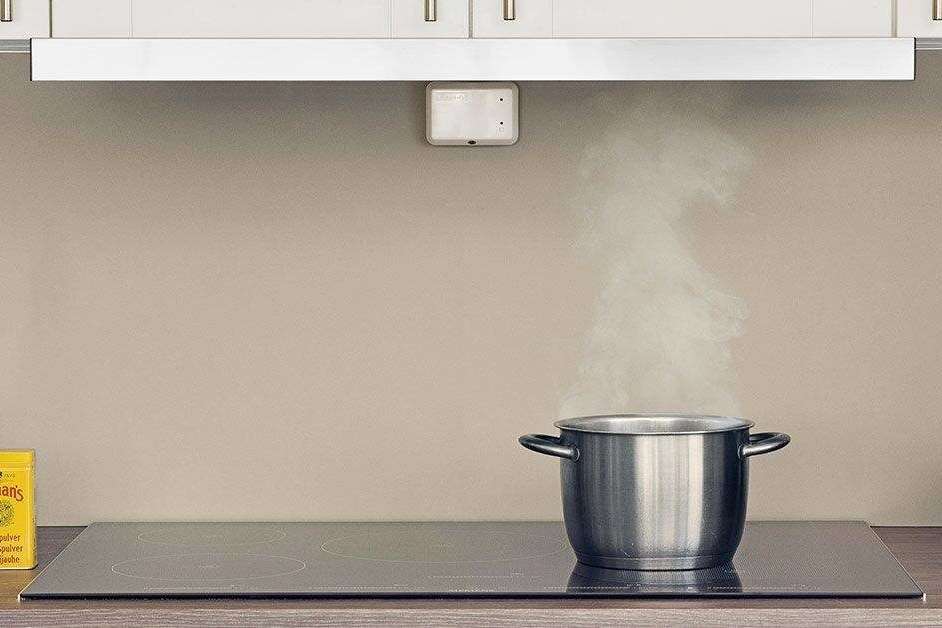 Komfyrvakt over platetopp med kjele som ryker