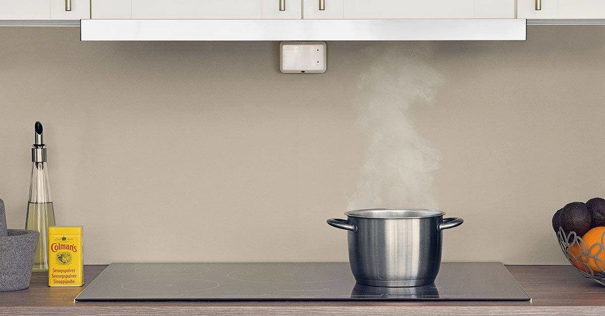 Komfyrvakt over platetopp med kjele som ryker